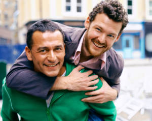 Gay man carrying his partner on his back