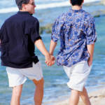 A gay couple enjoying a walk on the beach during their honeymoon