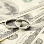 Silver wedding rings on one hundred dollars bill background