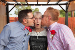 Woman Kissed by Two Men attendees of a same-sex wedding