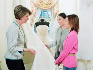 Gay-friendly wedding vendor helping young women pick bridal fabric
