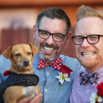 Happy Couple holding a small Dog