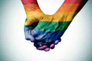 gay couple holding rainbow colored hands