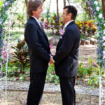 gay couple being married under arch