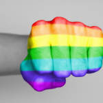 mans fist with rainbow flag overlay