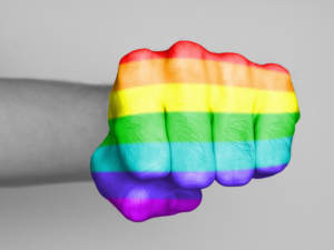 mans fist with rainbow flag overlay