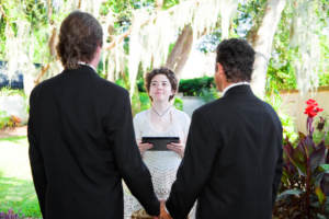 A gay couple standing with their officiant. Couples wish they knew.