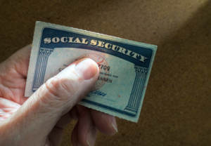 A person holding a social security card with their name on it.