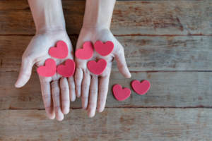 two hands holding hearts representing the chance to change the world