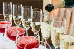 champagne being poured into glasses on a bar.