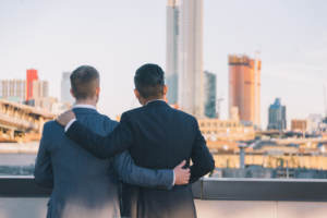 A newlywed couple enjoying the view from their rooftop wedding