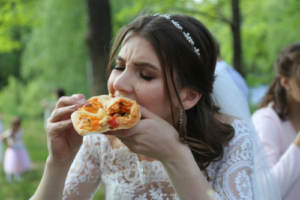 A bride having fun eating food with her hands