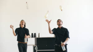 Two men showing off their skills at mobile bartending