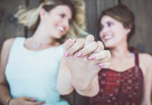 An LGBTQ couple engaged to be married and clasping hands