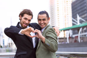 A same-sex couple shaping their hands into a heart after reading these tips on engagements