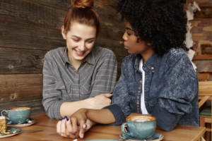 An interracial lesbian couple sitting to discuss topics about their coming wedding