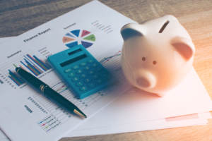 Piggy bank and calculator on papers with tips for finances