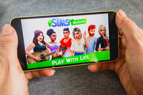 Playing The Sims Mobile game on a smartphone