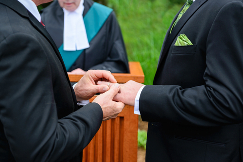 gay couple exchanging wedding rings