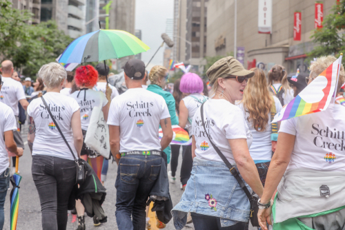 Crowd wearing great LGBT Schitt's Creek shirts at a pride celebration 