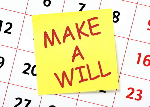 A sticky note on a calendar that says "make a will" to take care of your debts after death