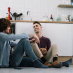 Gay couple having premarital conversations while sitting on the kitchen floor.