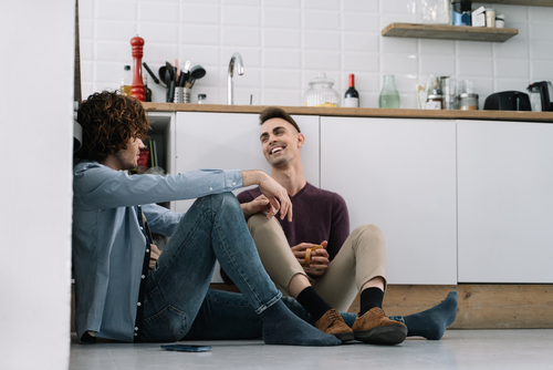 Gay couple having premarital conversations while sitting on the kitchen floor.