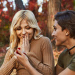 lesbian woman proposing to her partner in a park