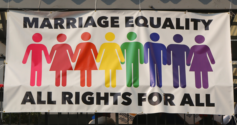 Marriage equality banner with male and female figures in rainbow colors