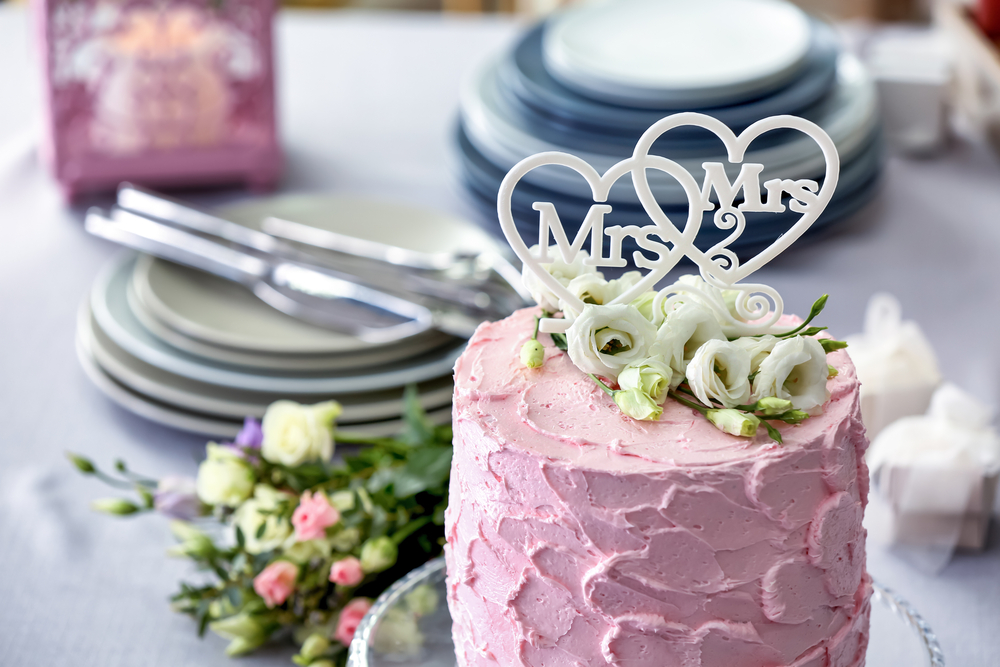 Pink wedding cake on a table for same-sex weddings