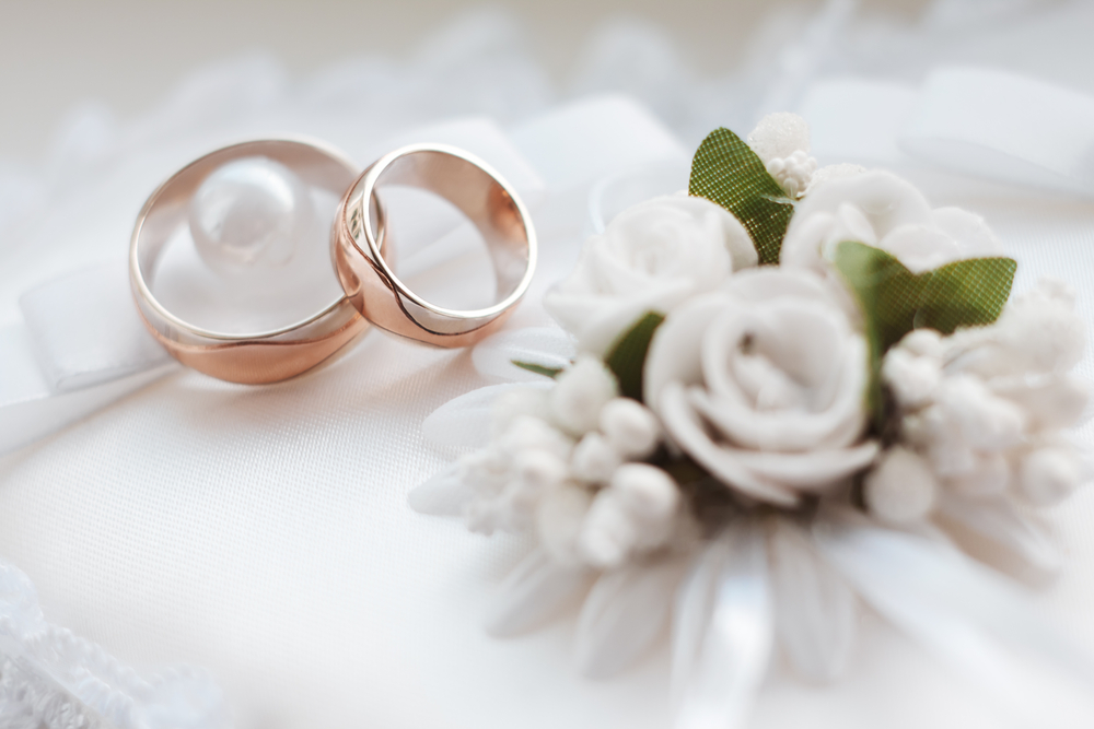 Wedding rings next to a white flower when breaking wedding traditions
