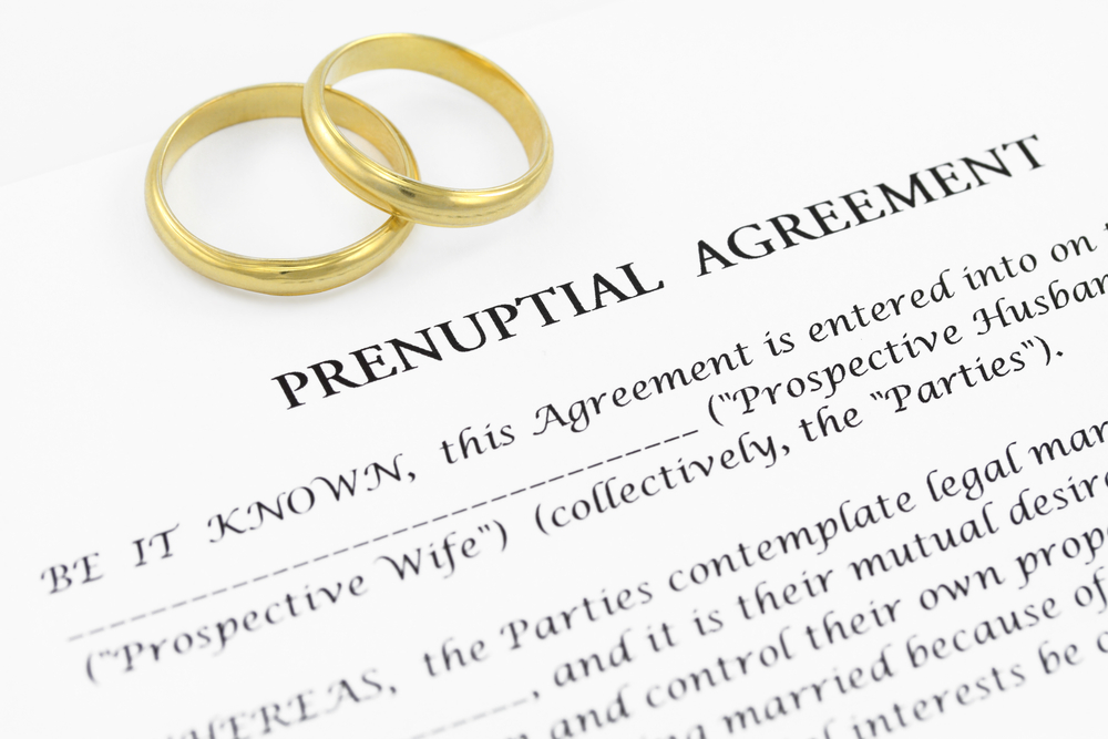 wedding rings on a prenuptial agreement form representing prenups and Same-sex couples