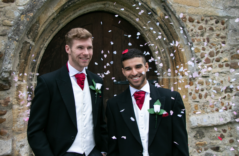 Two men in tuxedos smiling because of their creative wedding ideas