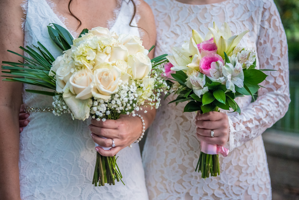 lesbian couple holding flower bouquets executing their perfect same-sex wedding plan